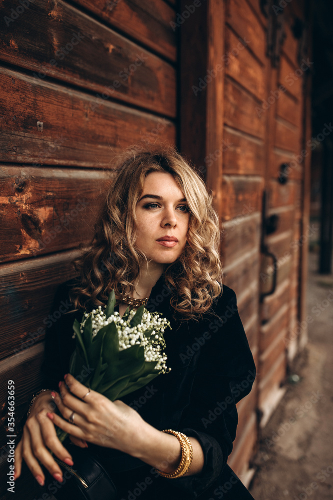 Photo session of a stylish girl outdoors. Young model on a background of a wooden barn.
Photo session of a stylish girl outdoors. Young model on a background of a wooden barn.