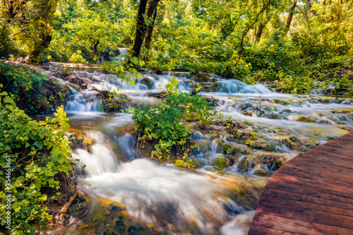 Wonderful summer view of Skradinski Buk waterfall with wooden bridge. Bright morning scene of Krka National Park  Lozovac village location  Croatia  Europe. Beautiful world of Mediterranean countries.