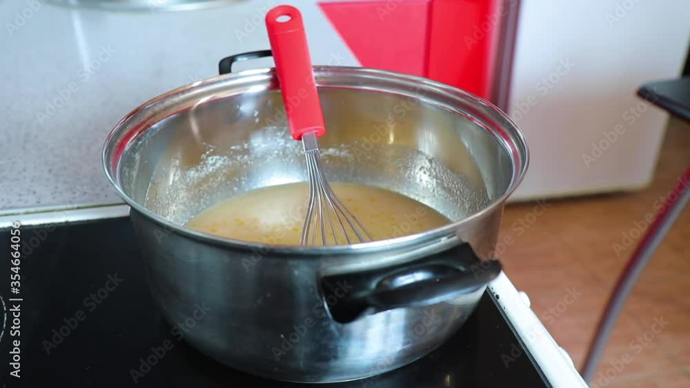 timelapse woman preparing cream for cake in a pan on the stove in the kitchen timelapse woman preparing cream for cake in a pan on the stove in the kitchen