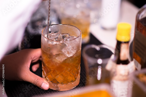 Bartender pouring cocktail in glasses