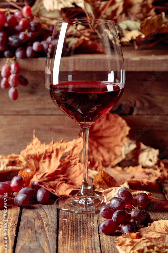 Wine, grapes and dried up vine leaves on a old wooden table. Wine, grapes and dried up vine leaves on a old wooden table.