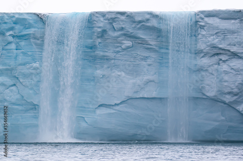 A water fall on the ice cliffs of Nordauslandet in Svalbard, in the Arctic
