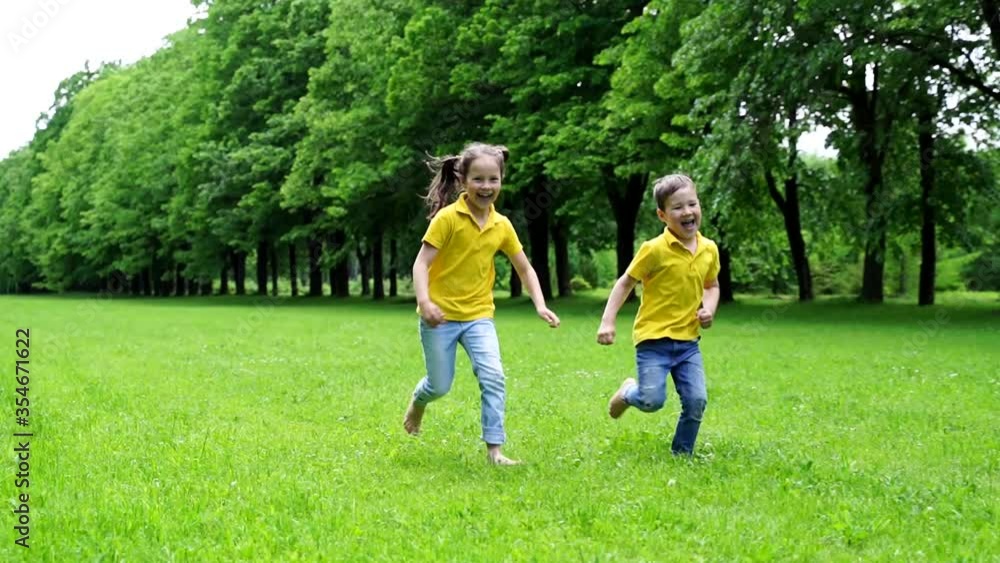 happy healthy children in bright t shirts running barefoot on the grass happy healthy children in bright t shirts running barefoot on the grass