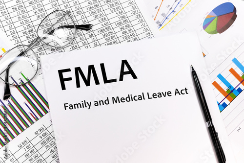 FMLA family medical leave act Concept. the inscription on the sheet. pen, glasses, documents, graphics. photo
