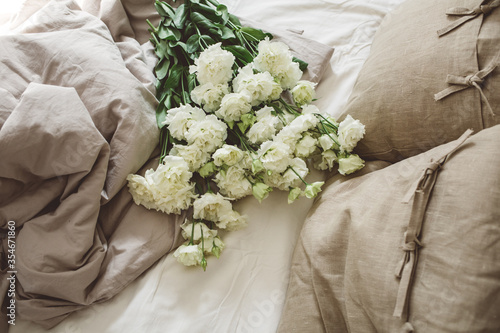 On the bed a bouquet of white eustoms photo