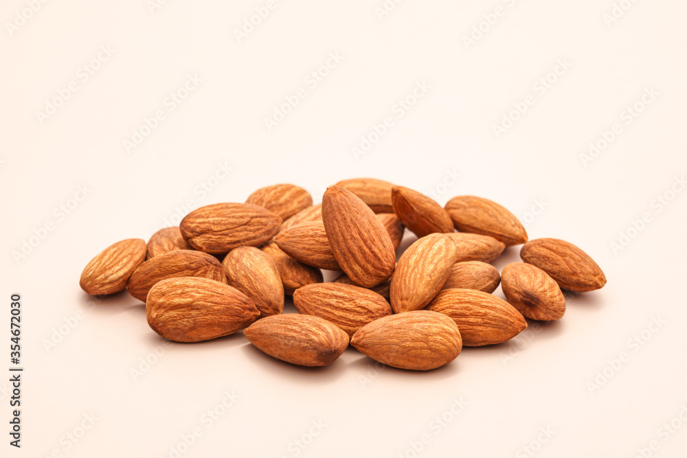 pile of organic peeled brown almonds isolated on the beige background concept of vegan raw ingredient for vegetarian snack and healthy food pile of organic peeled brown almonds isolated on the beige background concept of vegan raw ingredient for vegetarian snack and healthy food