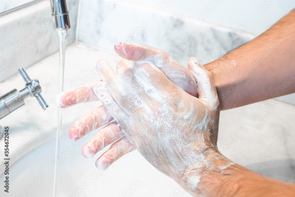 Fototapeta premium White Male Hands Being Cleansed With Soap and Water On a Bathroom Sink