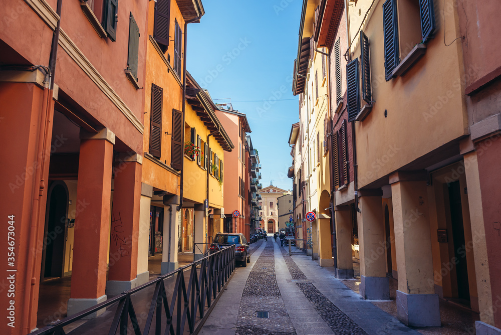 Narrow street with old residential buildings in historic part of Bologna city, Italy