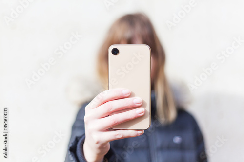 Wallpaper Mural Woman holds smartphone at camera depth of field instagram social media communication range lifestyle technology success no branding copy space Torontodigital.ca