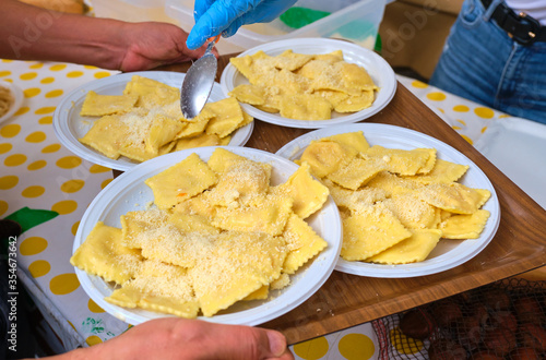 Freshly made ravioli pasta seasoned with parmesan cheese served at a fair festival outdoors in the Testaccio area, Rome Italy