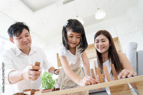 Asian family happy play wooden blocks board game, parent with kids activity together