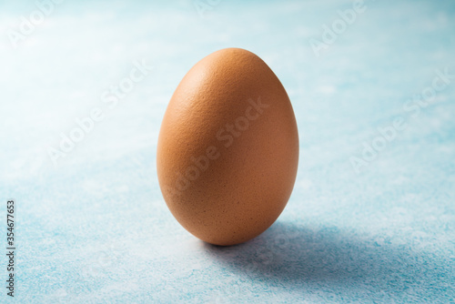 fresh clean chicken egg on a blue background as a food ingredient for cooking organic breakfast, good for health and high protein