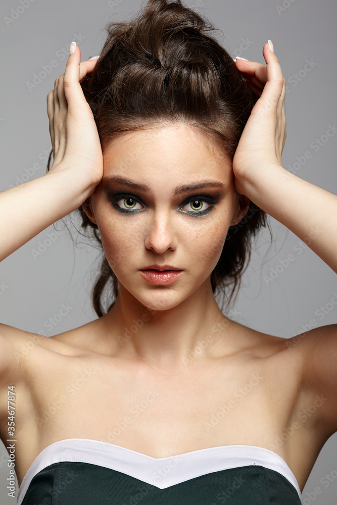 Beauty portrait of young woman with headache. Brunette girl with long hair and day female makeup