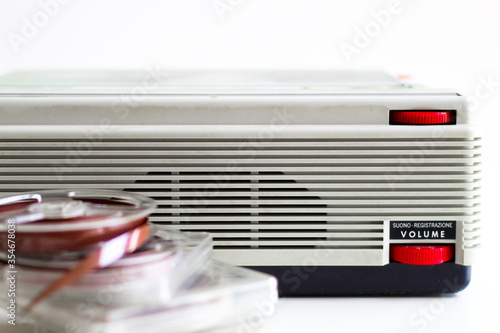 old tape recorder with magnetic tapes with recordings on white background photo