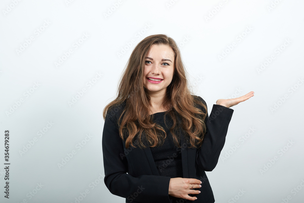 One hand is crossed, the other is raised up with palm, young attractive woman brunette in a black t-shirt and sweater on white background One hand is crossed, the other is raised up with palm, young attractive woman brunette in a black t-shirt and sweater on white background