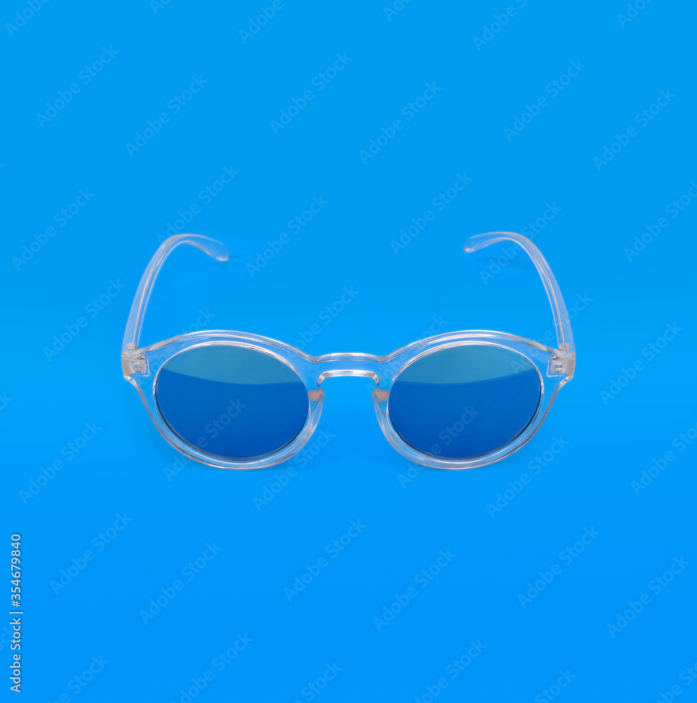 Fototapeta premium Sunglasses isolated on blue background for applying on a portrait