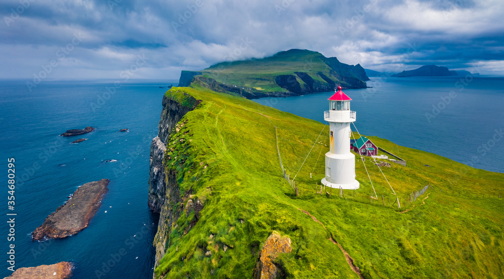 Gloomy view from flying drone of Mykines island with old lighthouse. Attractive morning scene of Faroe Islands, Denmark, Europe. Dramatic seascape of Atlantic ocean. Traveling concept background.. - obrazy, fototapety, plakaty 