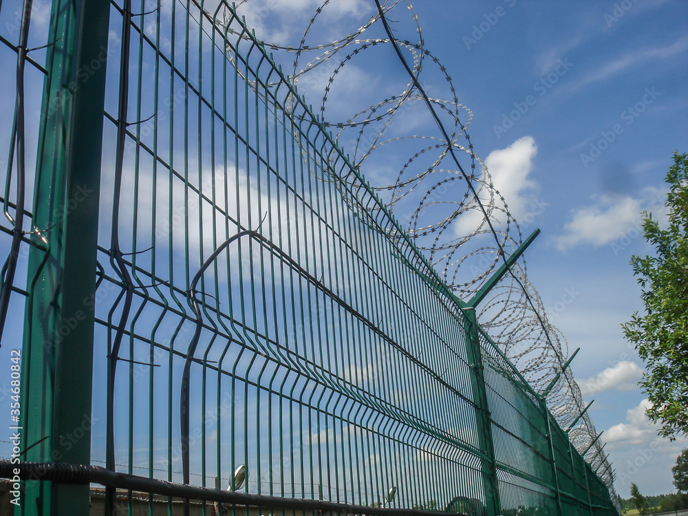 Fence with barbed wire on a guarded private territory. Fence with barbed wire on a guarded private territory.