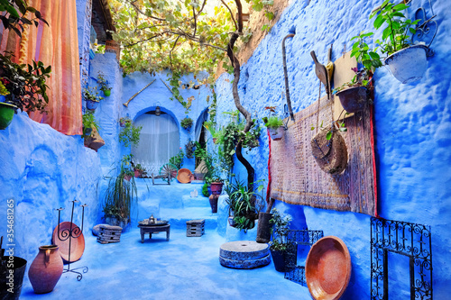 Cozy patio inside a blue house in medina of the blue city Chefchaouen, Morocco. Traditional moroccan architectural details. © Andrii Vergeles