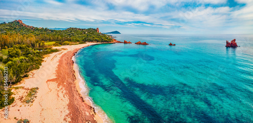 View from flying drone. Captivating summer view of di Cea beach with Red Rocks Gli Scogli Rossi - Faraglioni. Aerial morning scene of Sardinia island, Italy, Europe.  © Andrew Mayovskyy