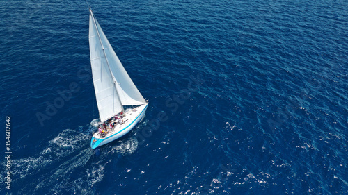 Aerial drone top down photo of beautiful sail boat cruising deep blue Aegean sea © aerial-drone