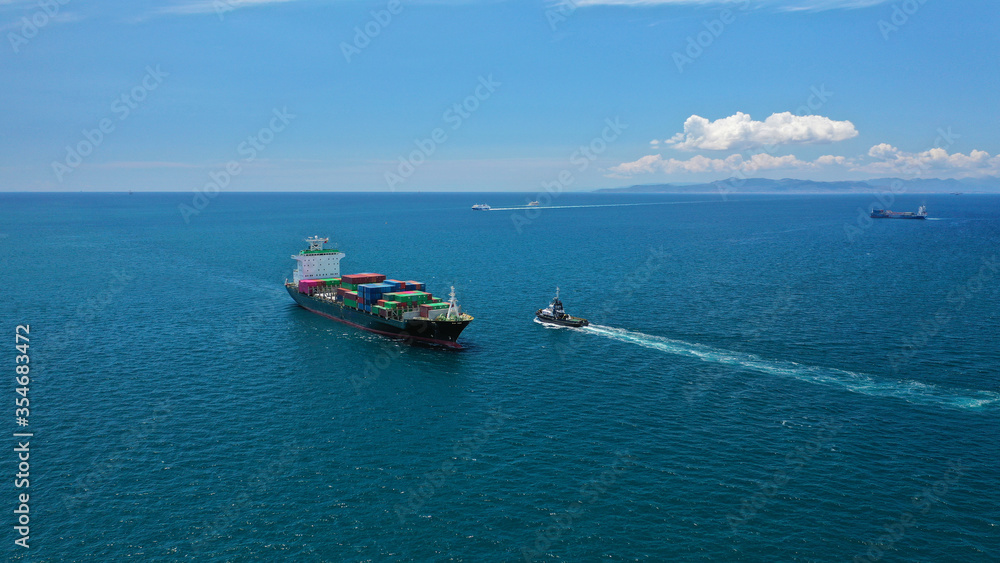 Aerial drone photo of fully loaded container cargo ship cruising in open ocean deep blue sea