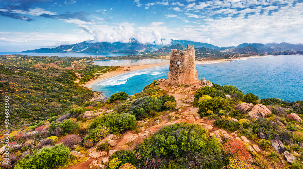 View from flying drone. Impressive summer view of Torre di Porto Giunco tower on Carbonara cape. Aerial morning scene of Sardinia island, Italy, Europe. Colorful Mediterranean seascape.