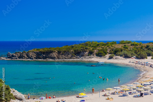 beach with holiday-makers, sun beds and umbrellas in village  (Rhodes, Greece) © p_r_g