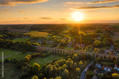 Photo The railway viaduct at Chappel and Wakes Colne in Essex, England the sun a gold