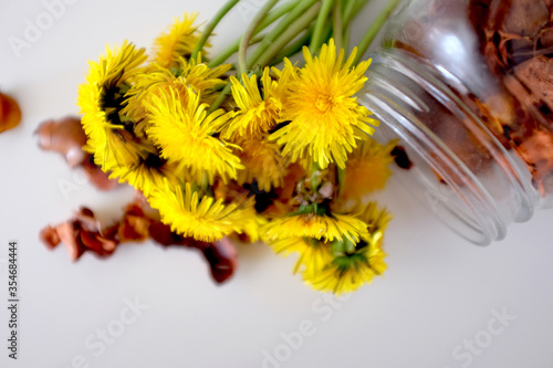 Bouquet of yellow dandelions in a jar on the table