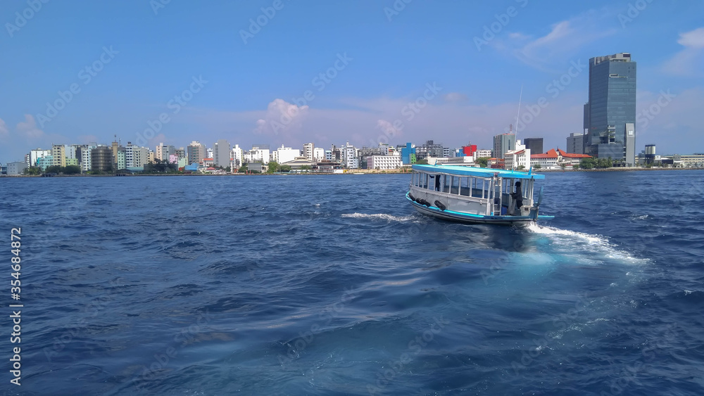 View of Male city and a boat from high sea. 