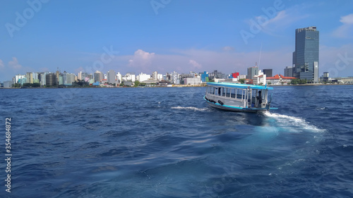 View of Male city and a boat from high sea. 