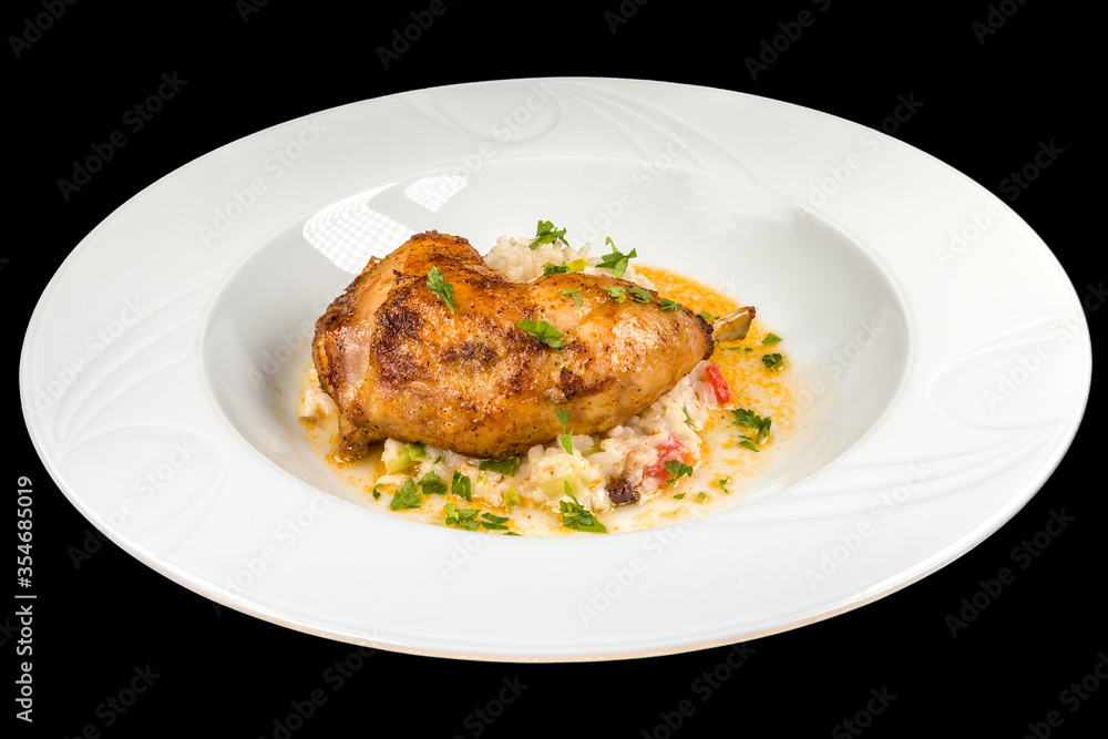 Delicious roasted chicken leg with vegetable risotto on a white plate, isolated on black background Delicious roasted chicken leg with vegetable risotto on a white plate, isolated on black background