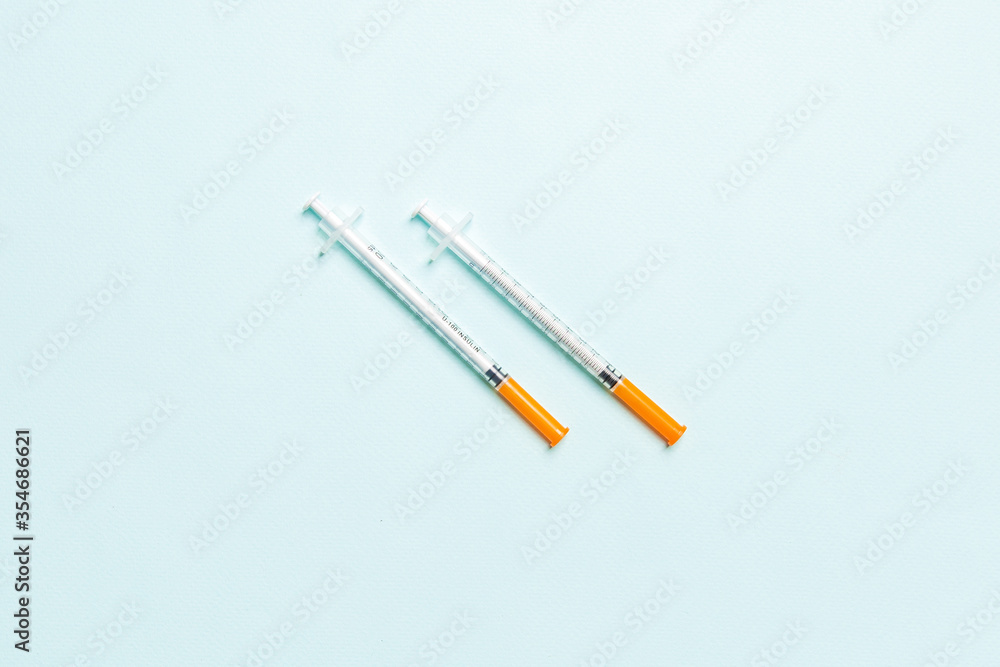 Top view of two insulin syringe at colorful background with copy space. High level of glucose concept Top view of two insulin syringe at colorful background with copy space. High level of glucose concept