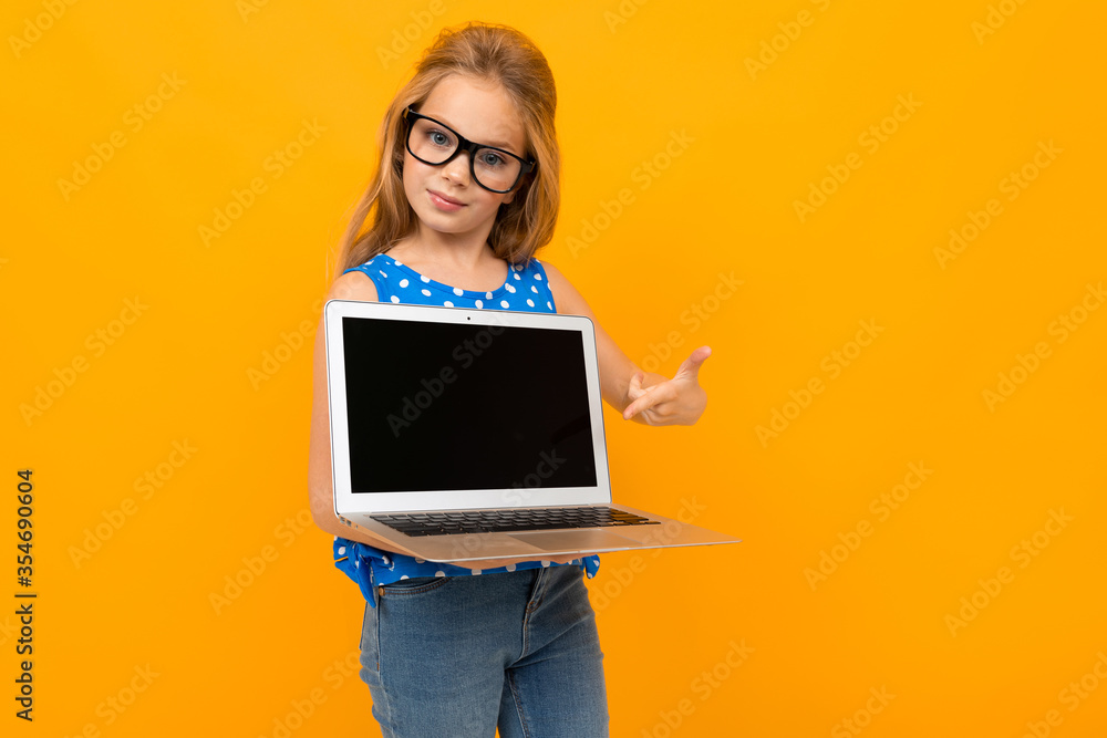Nice little girl with her glasses holds a laptop and smiles isolated on white background Nice little girl with her glasses holds a laptop and smiles isolated on white background