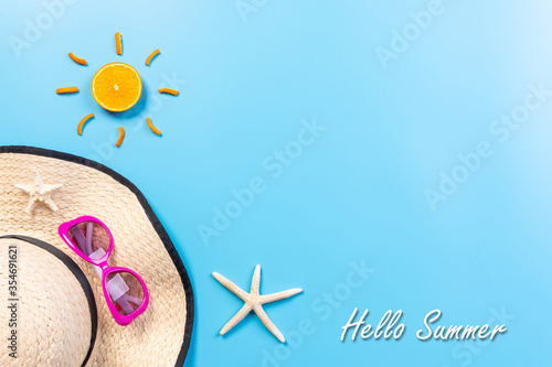 Summer holiday and vacation concept. Beach accessories sunglasses, starfish, sun, beach hat on blue pastel background with copy space for text.Top view.Summer time.