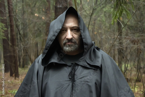 Portrait of a Monk in a black cassock in the forest, a wandering druid in a cassock. photo