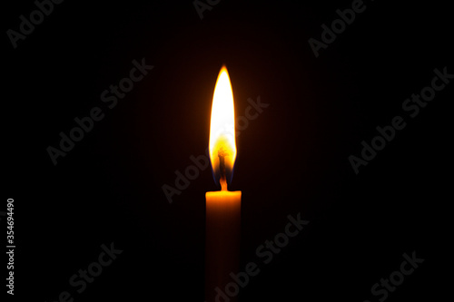 Close up single candle light and flame on black backgrou