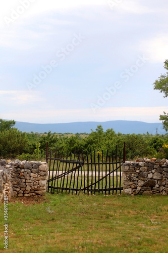 Traditional stone drywall and wooden fence in the countryside. Rural scene from Dalmatia region, Croatia.