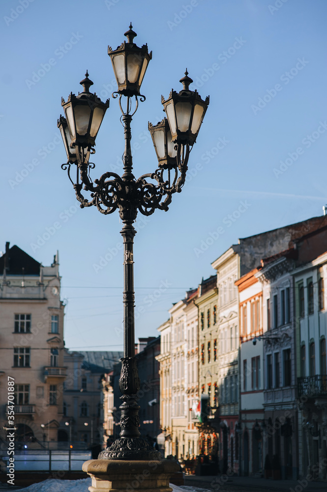 An old beautiful lantern in the historical center of Lviv on blue sky background. The concept of spring city.