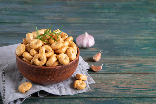 Traditional Italian snack tarallini in a ceramic bowl on a wooden background