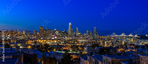 San Francisco skyline night panorama with city lights  the Bay Bridge and light trails on the highway