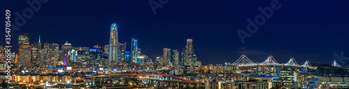 San Francisco skyline night panorama with city lights  the Bay Bridge and light trails on the highway