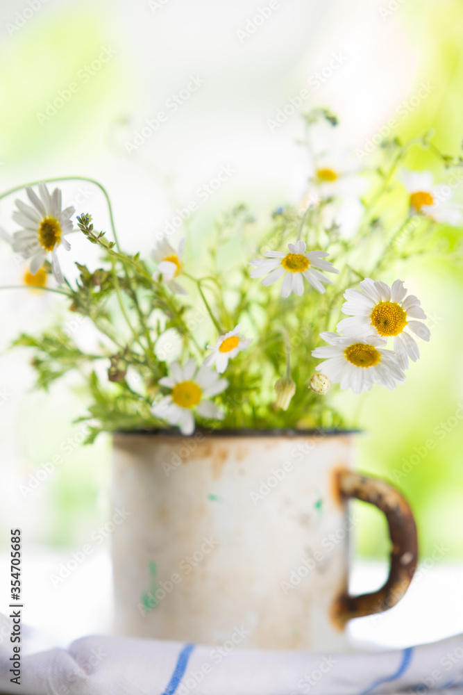 Fototapeta premium Wildflowers in an old metal mug. Summer concept.