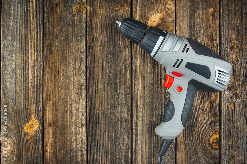 Electric drill on a wooden table. Copy space. Electric drill on a wooden table. Copy space.