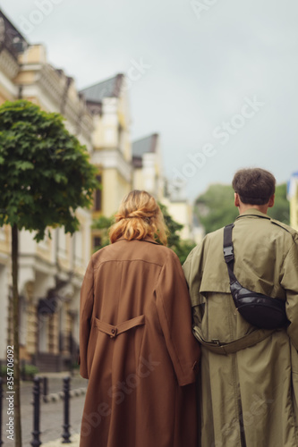 A couple in love walking down the street wearing vintage loose cloaks in Kiev