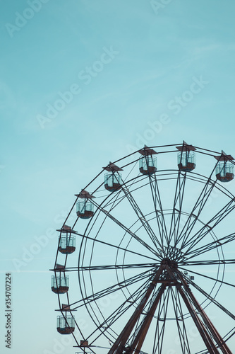 A long distance view of a a vintage Ferris Wheel fairground ride with blue sky background and copy space