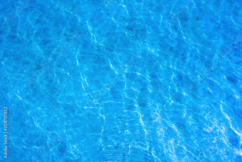 Texture of a blue water surface with light reflections