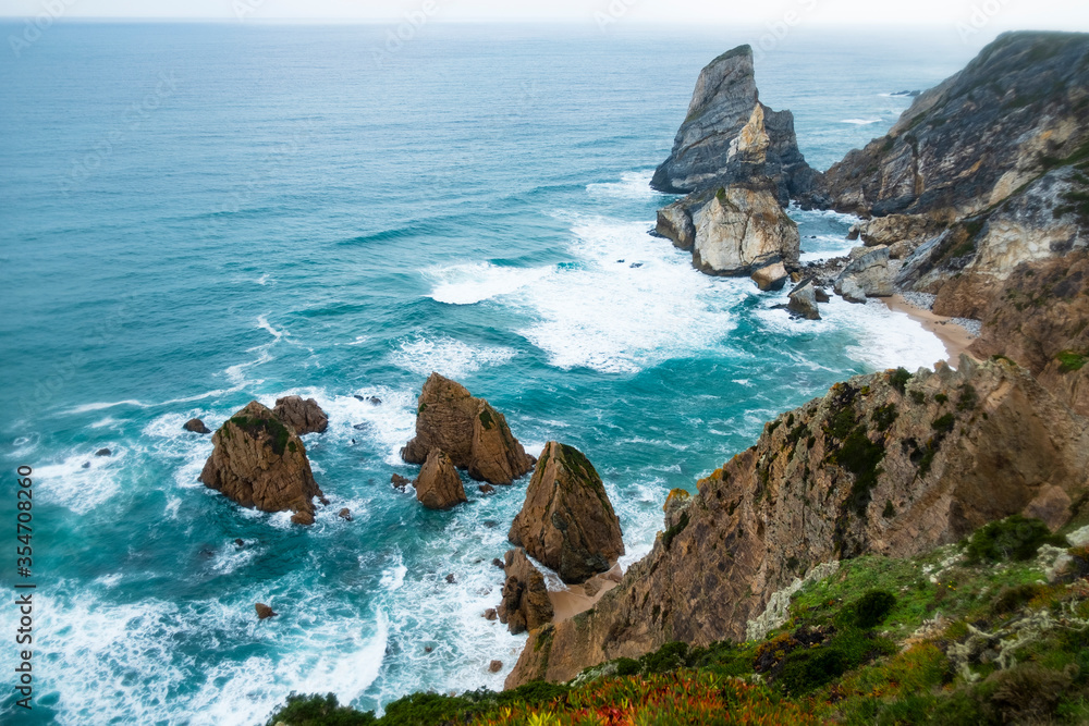 Beautiful rocks on the Atlantic ocean at Cape ROCA in Portugal in the middle of blue waves