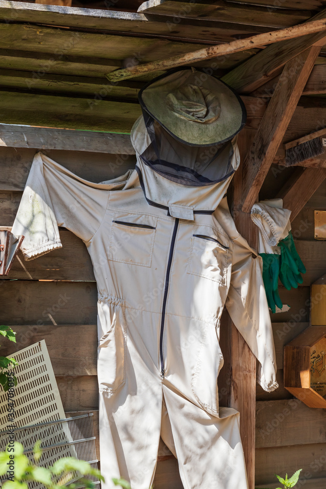 A white beekeeping suit hangs as an example at an outdoor display A white beekeeping suit hangs as an example at an outdoor display
